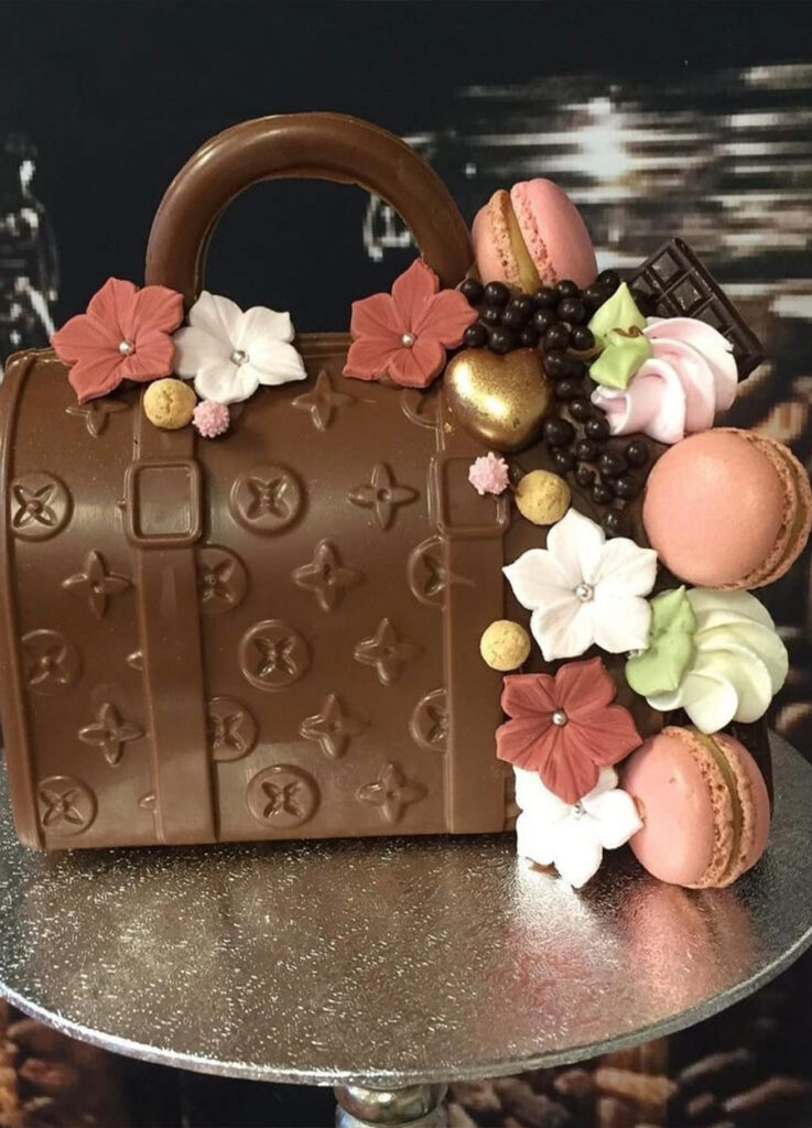 Designer bag: Wat een plaatje is het toch, deze prachtige tas is gemaakt van heerlijke melkchocolade en ook deze is versiert met handgemaakte decoratie en macarons. (Afmeting ong. 23 cm)